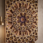 An intricate 3D carved wooden wall art piece featuring a complex geometric and floral mandala pattern in shades of brown, gold, and beige, mounted on a textured beige wall with a brass lamp visible on the left. image 6